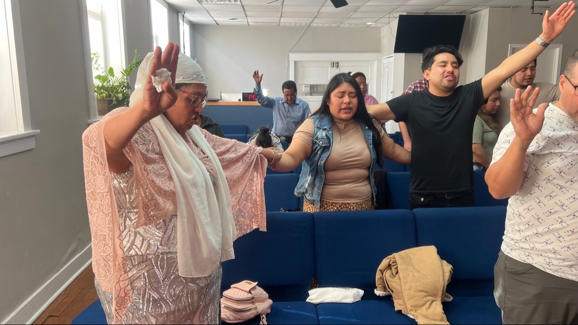 La congregación adorando con las manos levantadas