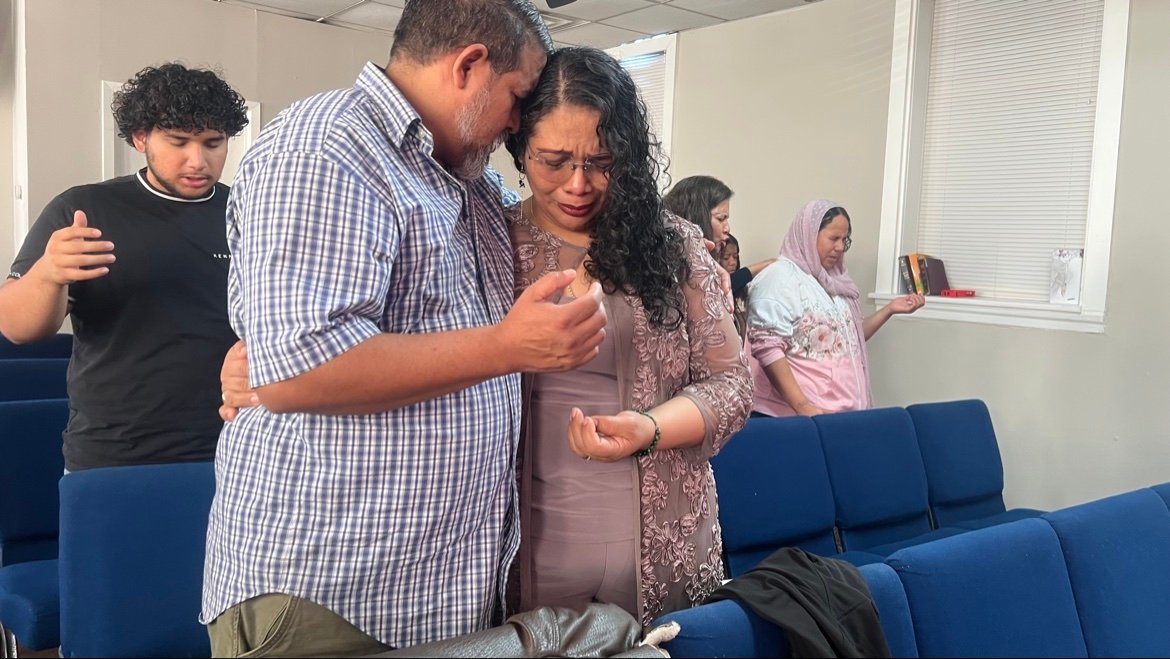 Un matrimonio abrazándose en oración durante el servicio